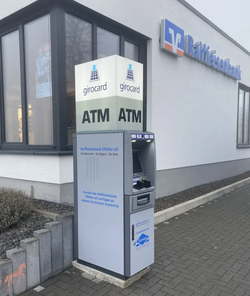 Abbildung - Euronet betreibt Geldautoamt der Raiffeisenbank Eifeltor eG im Partnerbranding (Raiffeisenbank Logo und Euronet Logo)