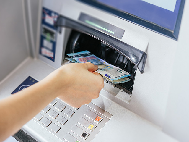 Abbildung - Geldautomat bei der Auszahlung von Bargeld